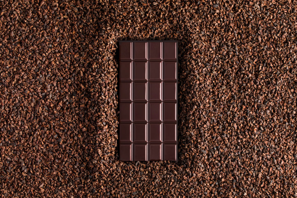 Tablette de chocolat noir posée sur des copeaux de chocolat